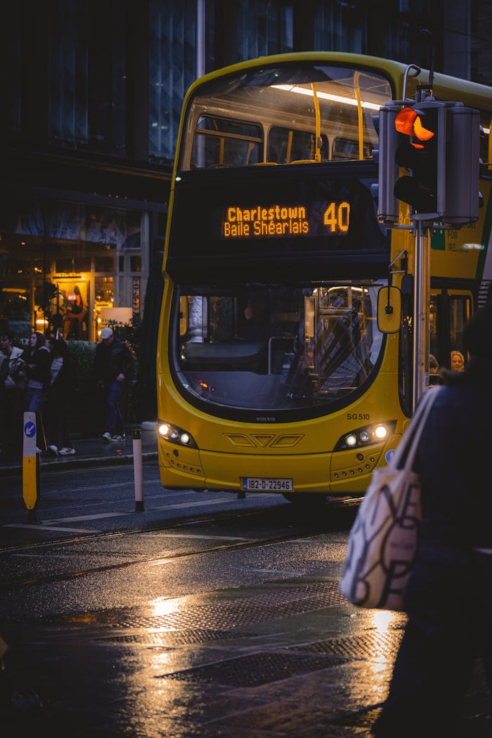 A yellow double decker bus is driving down the street